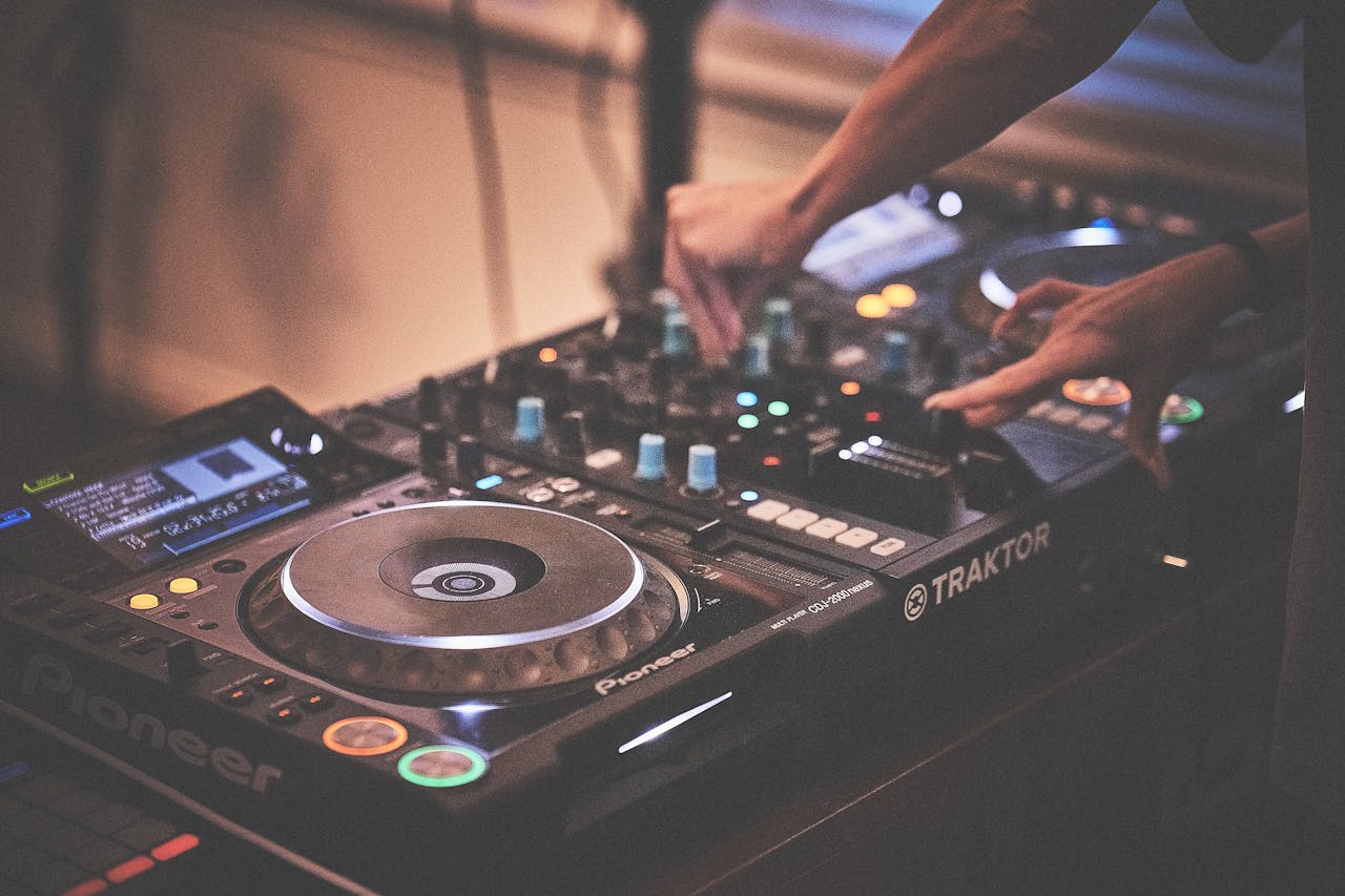DJ's hands adjusting a mixer during a live music performance.
